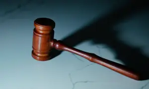 Drewniany młotek sędziowski na marmurowym blacie. Zastanawiasz się, ile trwa apelacja w sądzie okręgowym?