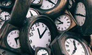 Zbliżenie na wiele starych zegarów ściennych z różnymi tarczami i wskazówkami.