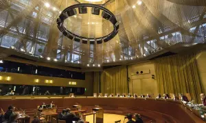 Wnętrze sali sądowej Trybunału Sprawiedliwości Unii Europejskiej, z sędziami w togach i publicznością.
