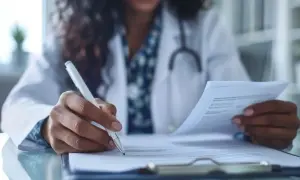 Lekarz wypełnia dokumentację medyczną, zastanawiając się, jak długo jest ważne skierowanie do specjalisty.
