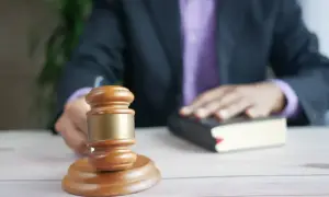 Sędzia kładzie rękę na księdze, obok młotka. To symboliczny moment, który może być związany z tym, jak liczyć uprawomocnienie wyroku.