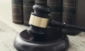 Młotek sędziowski i księgi prawne. Symbol sprawiedliwości, która może prowadzić do odwieszenia wyroku kiedy do więzienia.
