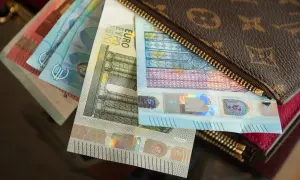 Euro banknoty w portfelu z monogramem.