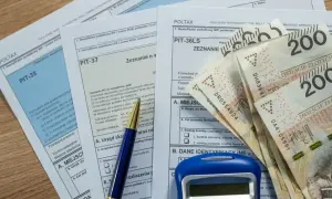 Wstępny kto to? Formularze PIT, długopis i pieniądze – przygotowanie do rozliczenia podatkowego.
