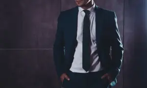 Elegancki mężczyzna w granatowym garniturze i białej koszuli. Kto to? Referent, który zawsze wygląda nienagannie.