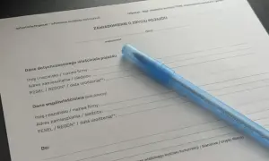 Formularz "Zawiadomienie o zbyciu pojazdu" z niebieskim długopisem. Dokument zawiera pola do wpisania danych poprzedniego właściciela i współwłaściciela pojazdu.