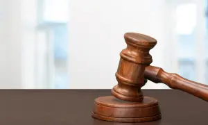 Młotek sędziowski na drewnianym stole. Zastanawiasz się, ile czasu trwa uprawomocnienie wyroku?