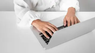 Osoba pisze na laptopie, przygotowując zaświadczenie o niezaleganiu ZUS.