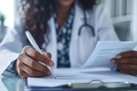 Lekarz wypełnia dokumentację medyczną, zastanawiając się, jak długo jest ważne skierowanie do specjalisty.