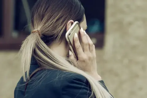 Kobieta rozmawia przez telefon, zastanawiając się, ile dni potrwa siła wyższa.