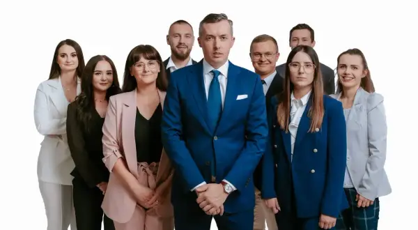 Grupa profesjonalistów w garniturach i kostiumach, pozująca do zdjęcia na białym tle.