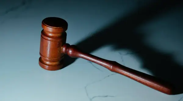 Drewniany młotek sędziowski na marmurowym blacie. Zastanawiasz się, ile trwa apelacja w sądzie okręgowym?
