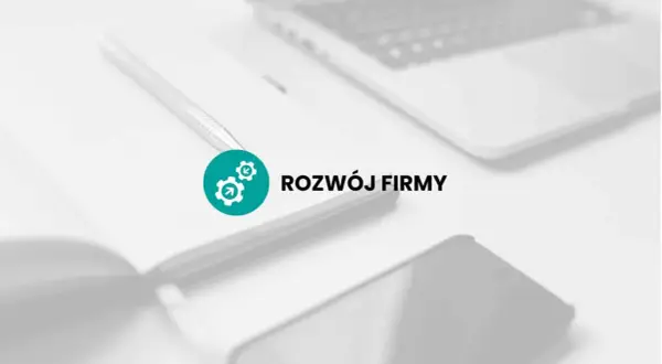 Na biurku leży notatnik z długopisem, obok laptop i telefon. Ikona z trybikami symbolizuje rozwój firmy, czyli jej promesa.