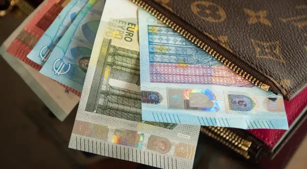 Euro banknoty w portfelu z monogramem.