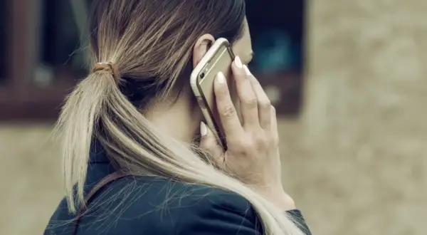 Kobieta rozmawia przez telefon, zastanawiając się, ile dni potrwa siła wyższa.