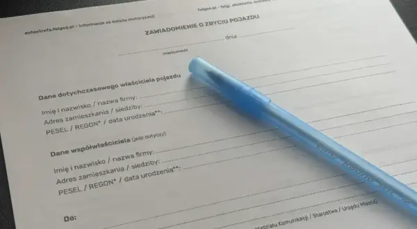 Formularz "Zawiadomienie o zbyciu pojazdu" z niebieskim długopisem. Dokument zawiera pola do wpisania danych poprzedniego właściciela i współwłaściciela pojazdu.