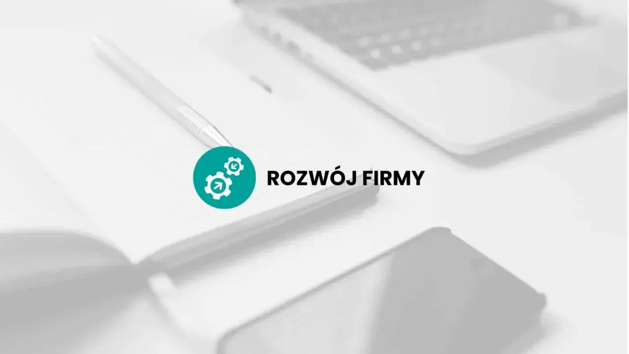 Na biurku leży notatnik z długopisem, obok laptop i telefon. Ikona z trybikami symbolizuje rozwój firmy, czyli jej promesa.
