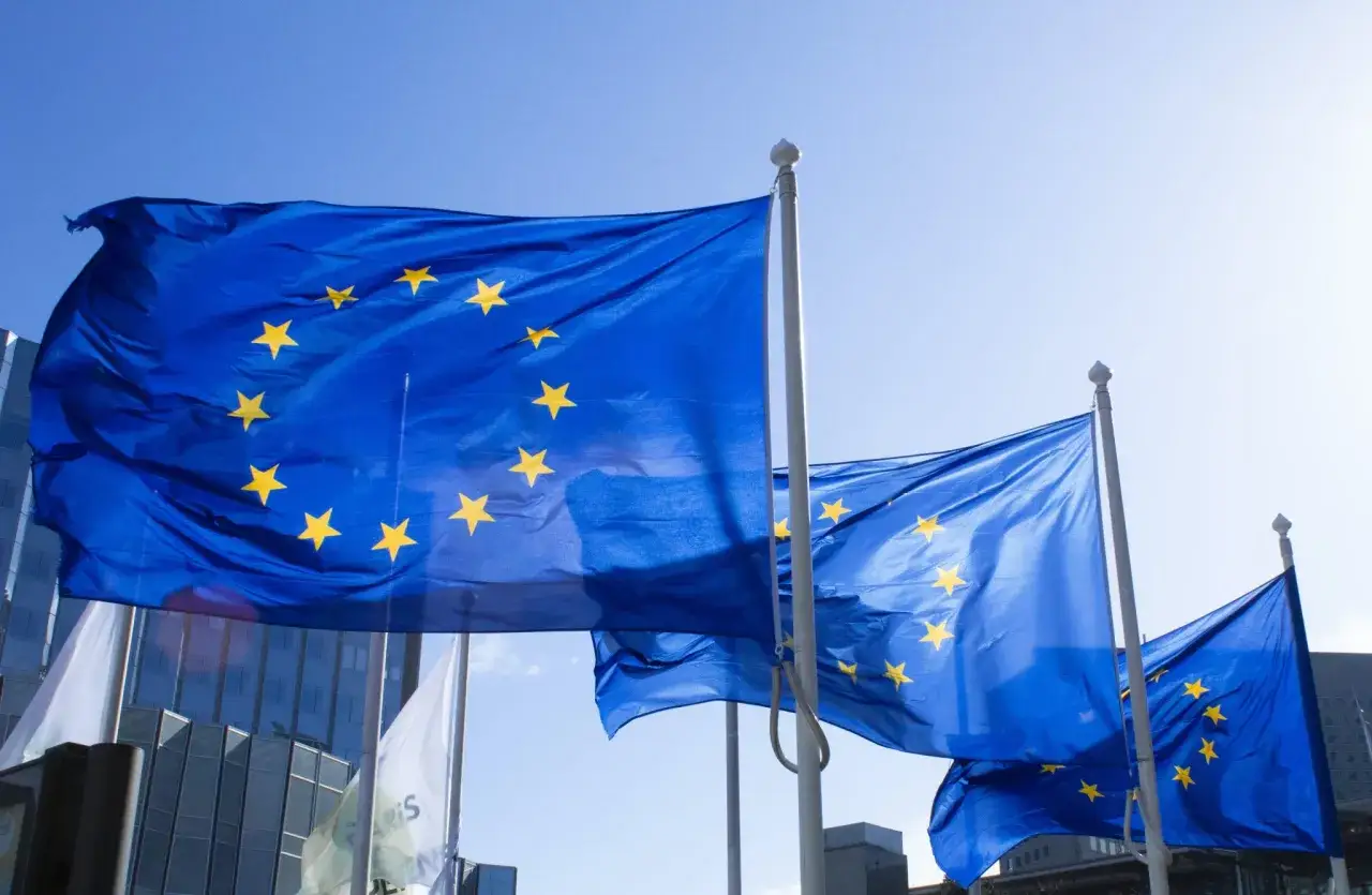 Flagi Unii Europejskiej powiewają na wietrze. Symbolizują jedność i wspólne cele, jak nowa dyrektywa.