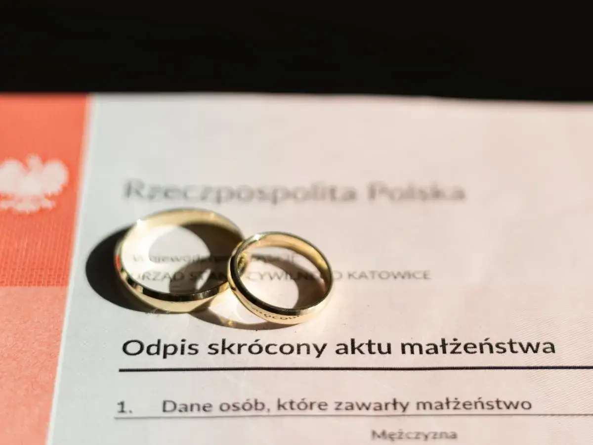 Złote obrączki na odpisie aktu małżeństwa. To nie konkubinat, to ślub!