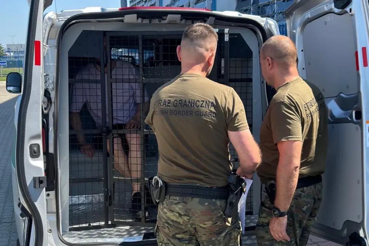 Strażnicy graniczni nadzorują transport osoby w klatce w samochodzie, przygotowując ją do deportacji.