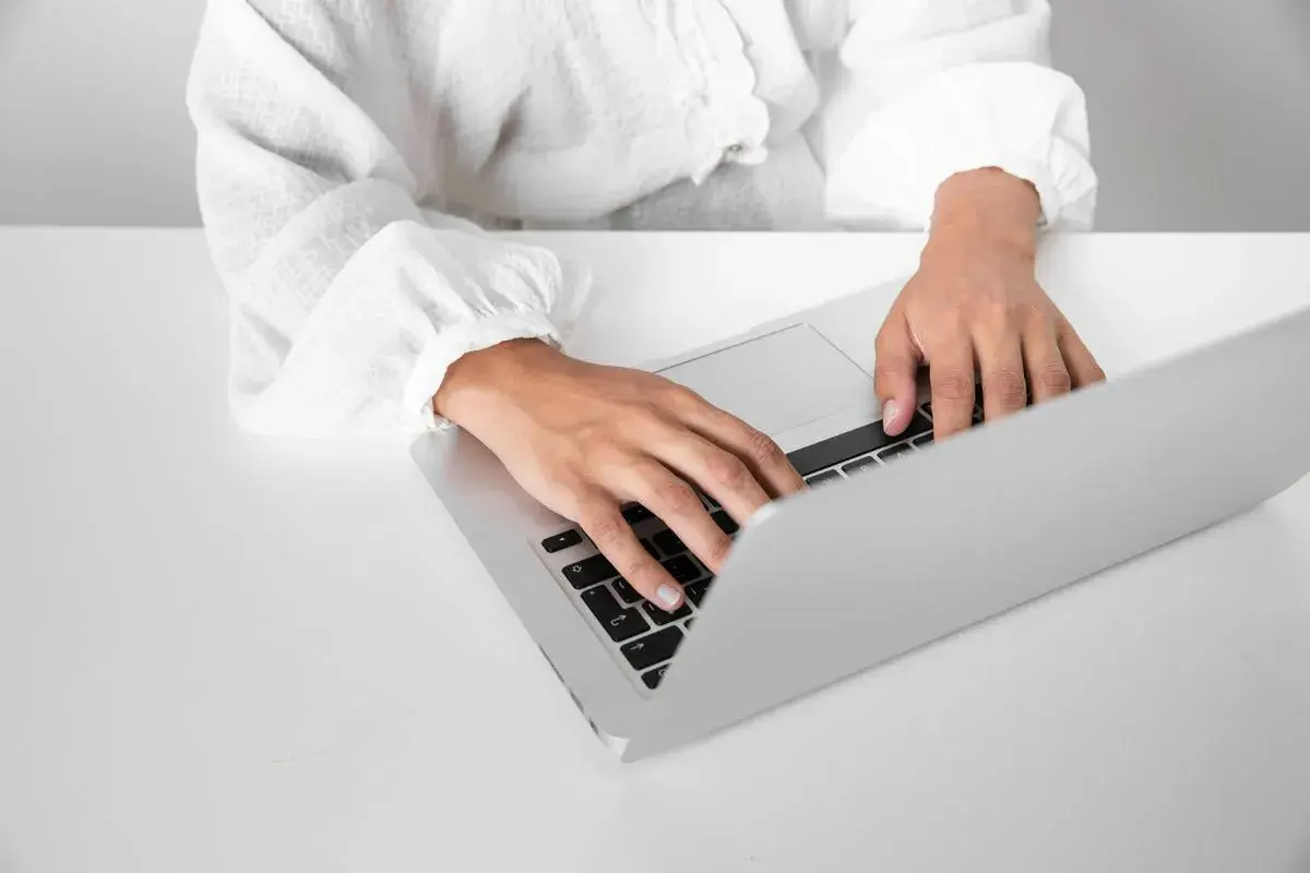 Osoba pisze na laptopie, przygotowując zaświadczenie o niezaleganiu ZUS.